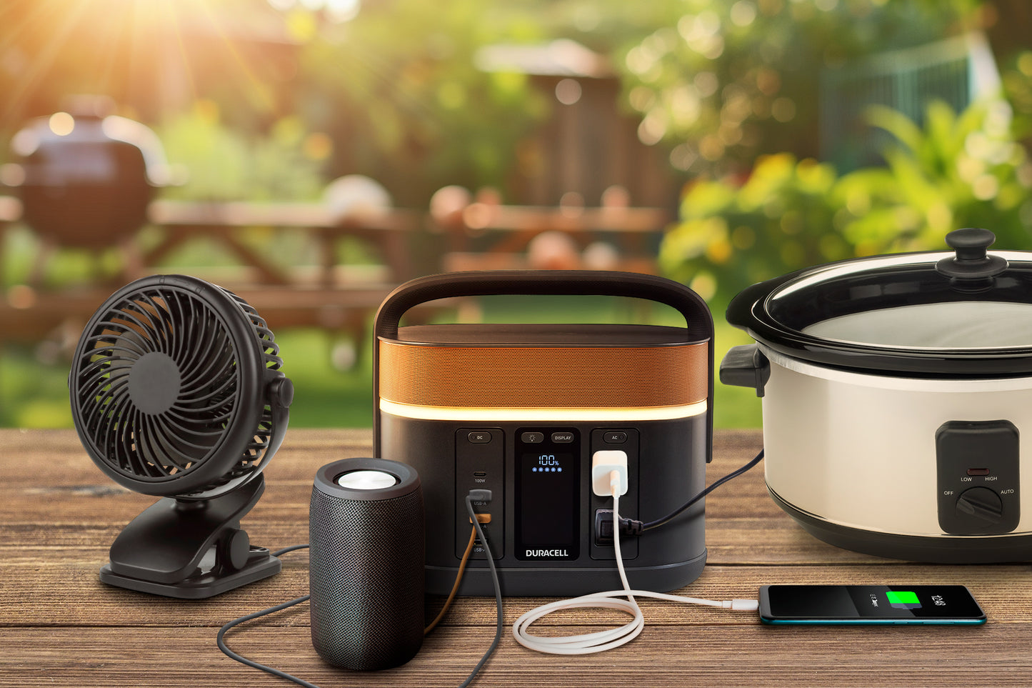 Duracell Portable Power Station outside charging multiple devices including a slow cooker and portable fan