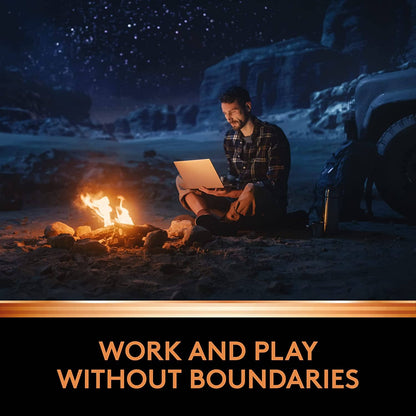 Image of someone camping by a bonfire while looking at his laptop. work and play without boundaries.